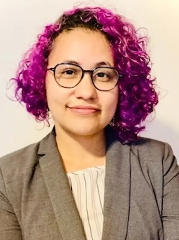 5 Person with curly purple hair, wearing glasses.