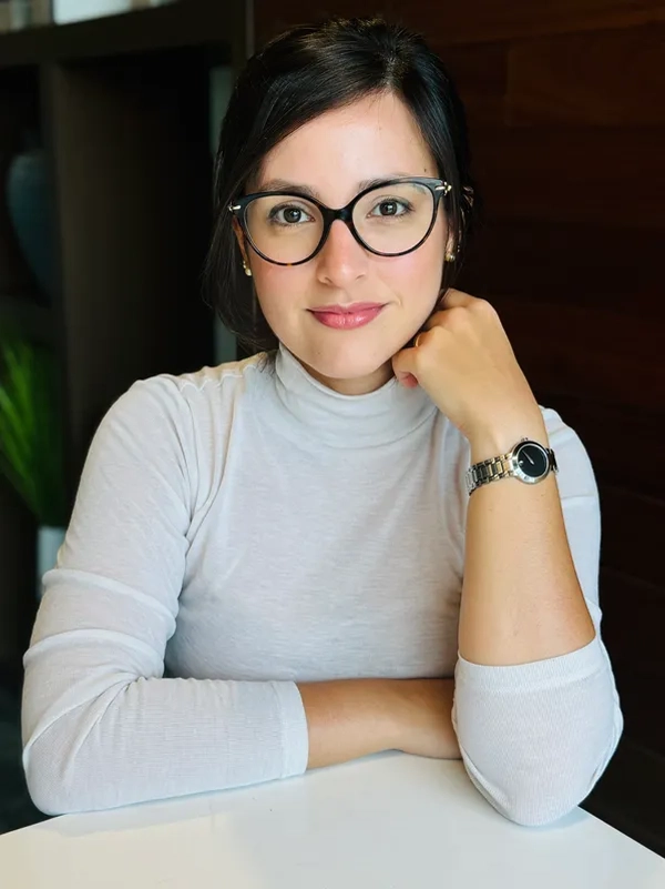 6 Person wearing glasses and a white turtleneck.