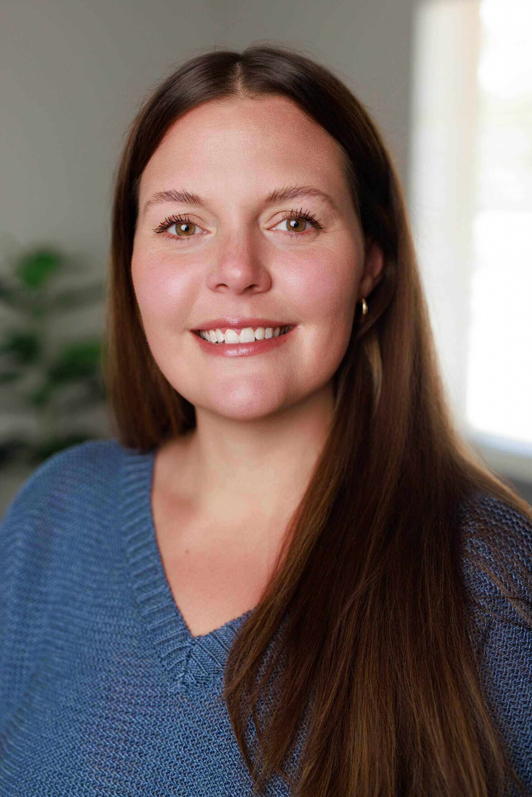 Smiling woman in a blue sweater.