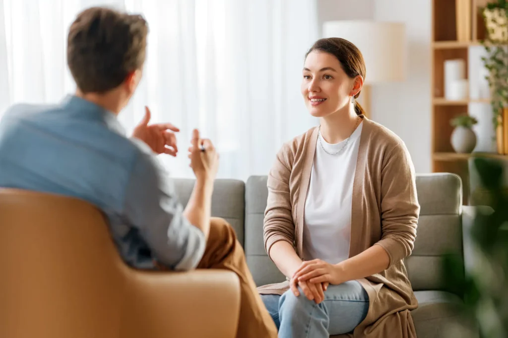 Two people having a conversation on sofa.